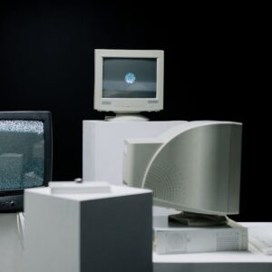 Vintage computer monitors arranged in a minimalist setup with a dark background, showcasing technology evolution.
